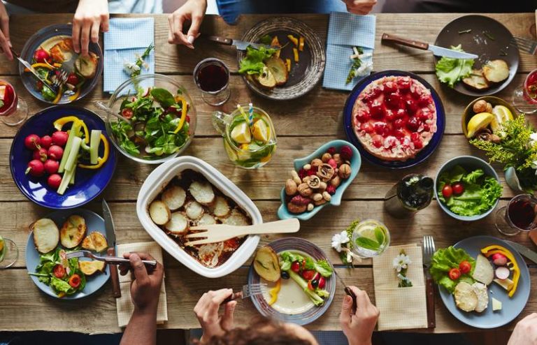 Tisch mit Menschen mit gesunden Lebensmitteln